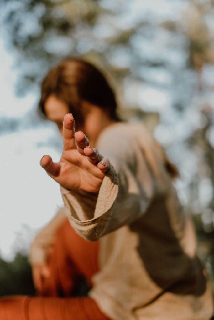 Artistic image of a woman reaching with an outstretched hand, evoking motion and emotion.