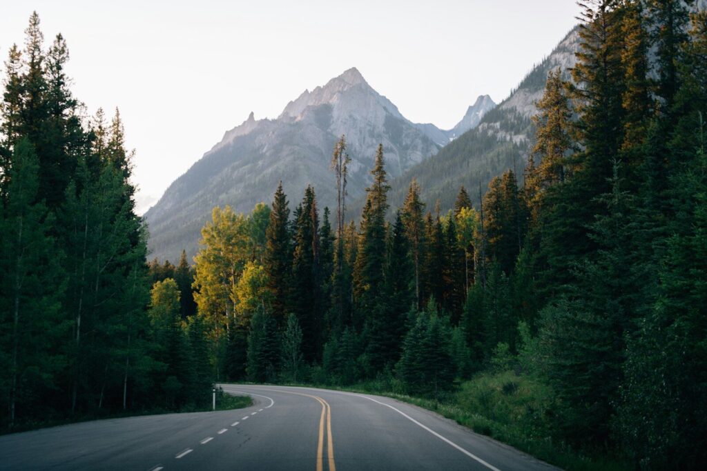 Winding road leads towards majestic mountains.
